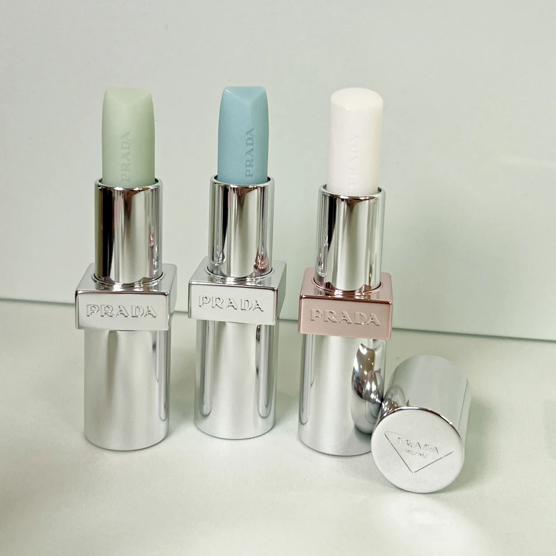 PRADA(左起)經典潤唇膏# U001莫測藍、U000顛覆綠、原生稜光水唇膏#U014幻光白。