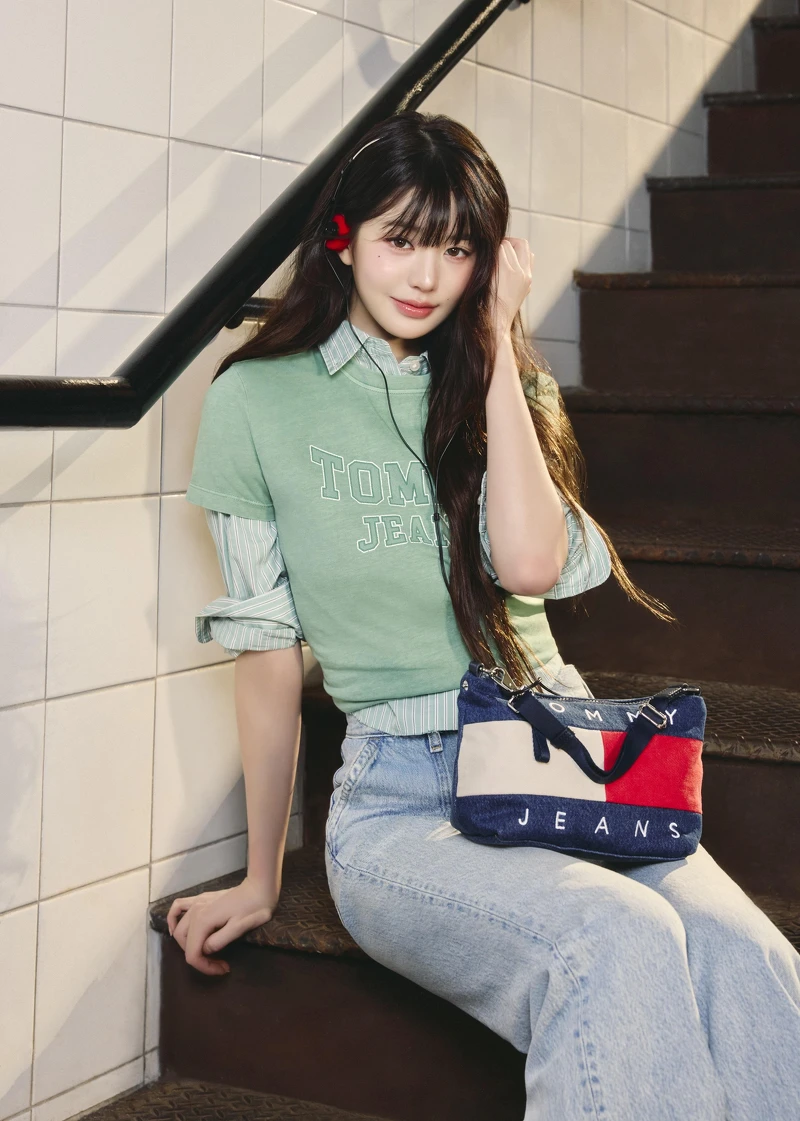 學院標誌 T 恤、短版寬鬆徽章襯衫、高腰喇叭牛仔褲、經典丹寧肩揹包 by TOMMY JEANS。 學院標誌 T 恤、短版寬鬆徽章襯衫、高腰喇叭牛仔褲、經典丹寧肩揹包 by TOMMY JEANS。