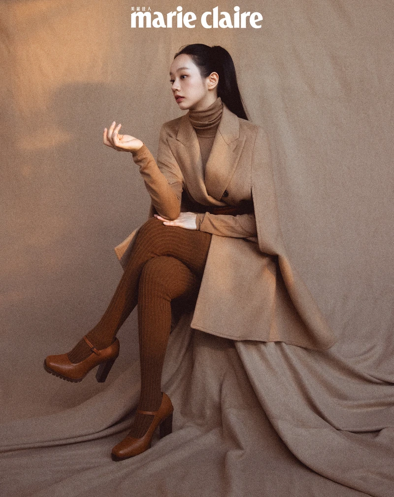 駱駝毛斗篷大衣、駝色高領羊毛衫、駱駝毛料西裝短褲、棕色牛皮腰帶、駝色羊毛褲襪、駝色瑪莉珍高跟鞋，all by Max Mara。