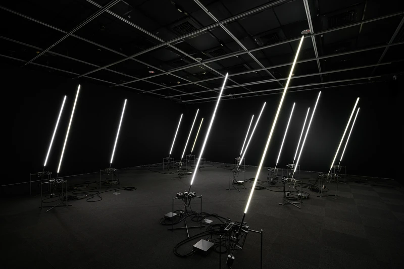 《風場II》將風的數據,轉化為機械與光影模擬自然律動,細長的發光體化為一片人工風林,在展場裡靜靜呼吸。|展出現場|當代館提供 《風場II》將風的數據,轉化為機械與光影模擬自然律動,細長的發光體化為一片人工風林,在展場裡靜靜呼吸。|展出現場|當代館提供