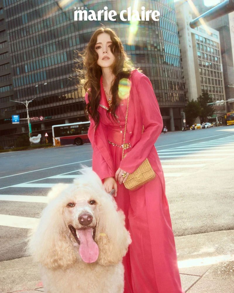 玫瑰色背心、玫瑰色襯衫、玫瑰色寬褲、項鍊、戒指、耳環、珍珠腰鍊、編織包、黑色高跟涼鞋，All by Chanel。