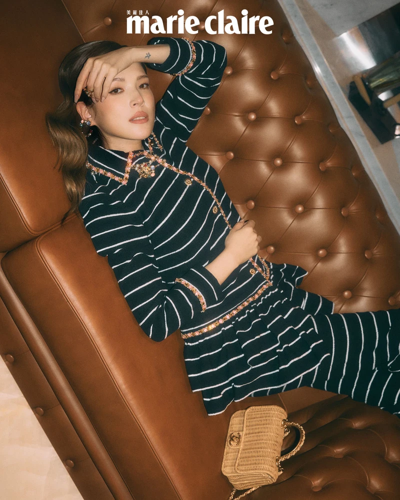 黑粉荷葉褶飾條紋外套與長褲、多彩寶石項鍊、竹編口蓋包，all by Chanel。