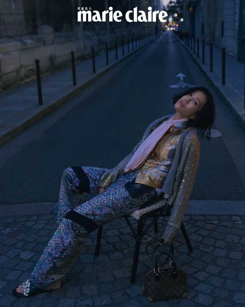 粉色領飾絲質襯衫、金色背心、金色刺繡針織外套、異材質拼接長褲、黑色露趾鑲鑽皮靴，All by Louis Vuitton。