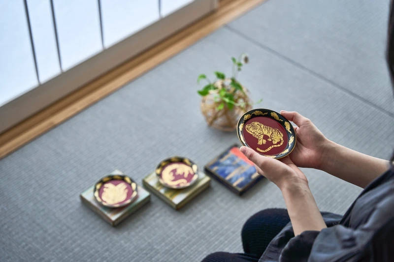 使用日本傳統漆藝與金箔,在小巧的豆皿上描繪象徵吉祥的動物。完成的豆皿可作為這段體驗的紀念帶回家。 使用日本傳統漆藝與金箔,在小巧的豆皿上描繪象徵吉祥的動物。完成的豆皿可作為這段體驗的紀念帶回家。