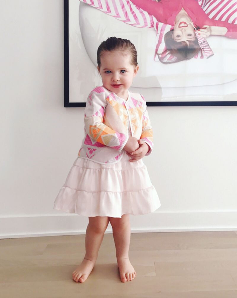 粉色的澎裙洋裝罩上剪裁立體的外套版型,再梳個乾淨的馬尾