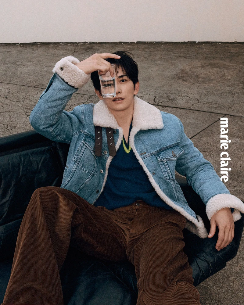 丹寧卡車司機外套、黃藍色V領針織衫、棕色長褲、小牛皮撞色德比鞋，All by Loewe。