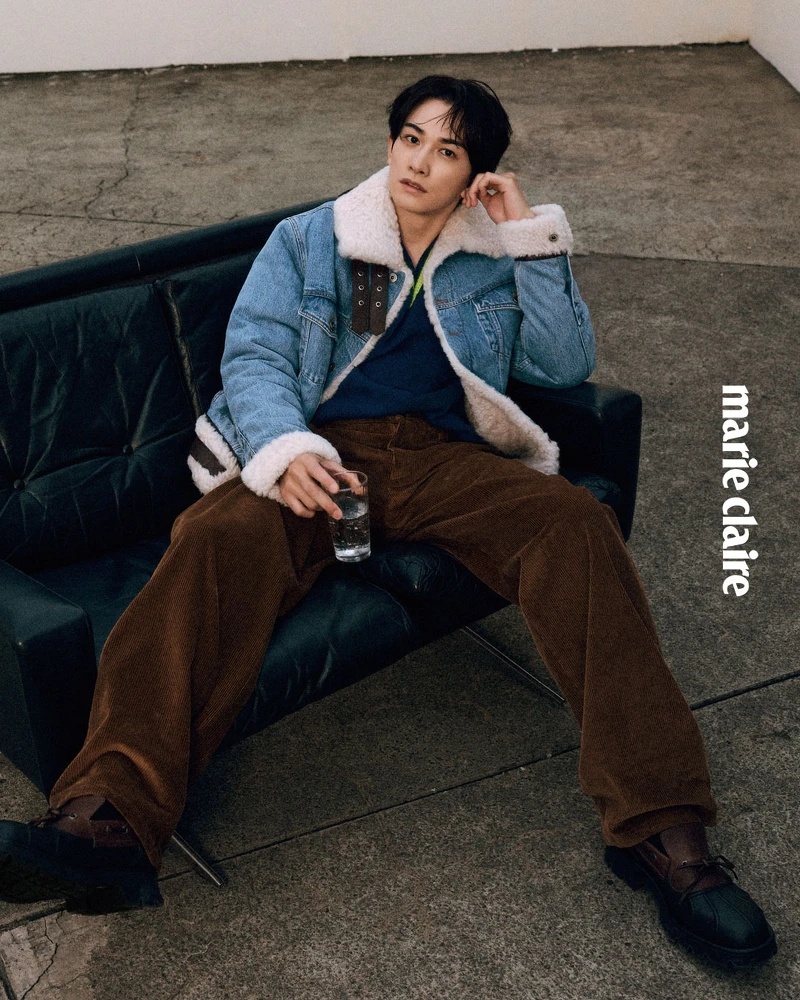 丹寧卡車司機外套、黃藍色V領針織衫、棕色長褲、小牛皮撞色德比鞋，All by Loewe。