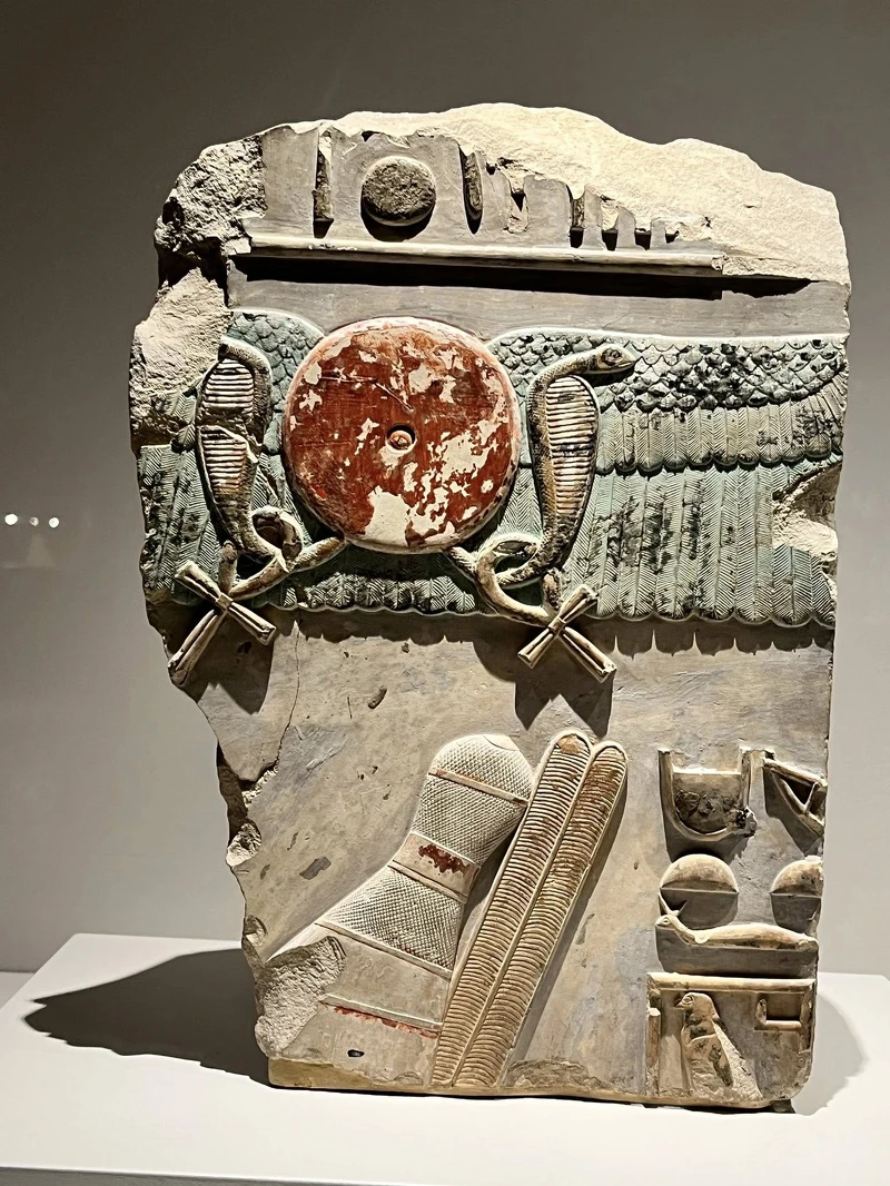 〈曼圖霍特普二世受太陽庇佑的祭廟浮雕〉,太陽圓盤兩側裝飾著聖蛇(uraeus) 與象徵生命的「安卡」。 〈曼圖霍特普二世受太陽庇佑的祭廟浮雕〉,太陽圓盤兩側裝飾著聖蛇(uraeus) 與象徵生命的「安卡」。